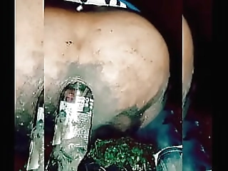 slutty transvestite wallowing in the mud, putting bottles up her ass